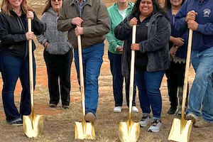 Image of people gathered with shovels for a ground breaking
